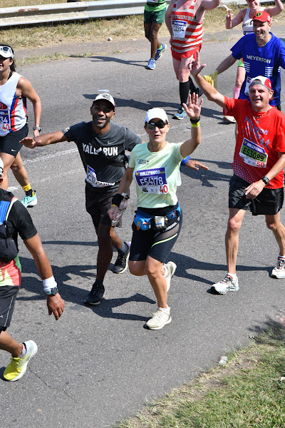 runners waving for the camera in The Comrades Ultramarathon