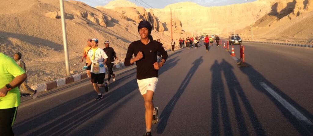 Runners running a marathon between 2 hills in the middle of the street